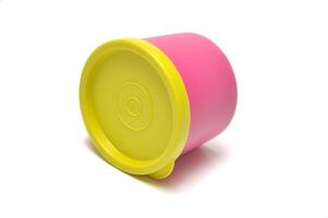 Pink tube plastic container with yellow lid white background photo