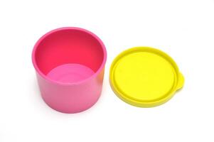 Pink tube plastic container with yellow lid white background photo