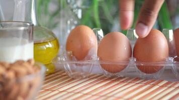A person is holding an egg in front of a tray of eggs video