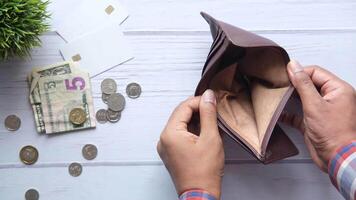 A man is holding an empty wallet with money and coins video