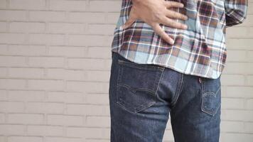 A man with back pain is holding his hand to his back video