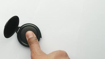 A person's hand touching a button on a black object video