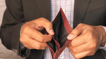 A man in a suit is holding an empty wallet video