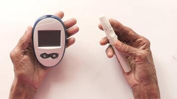 Two hands holding a glucose meter and a digital thermometer video