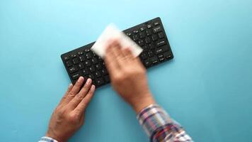 A person wiping down a keyboard with a cloth video