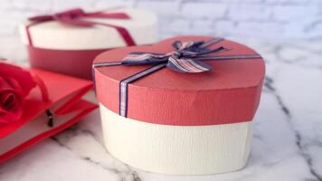 Two red and white boxes with red ribbons and a red rose video