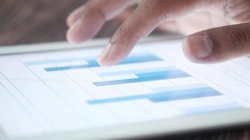 A person's hand is touching a tablet with a graph on it video