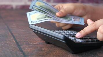 A person is using a calculator to count money video