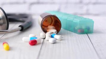 Pills and a stethoscope on a wooden table video