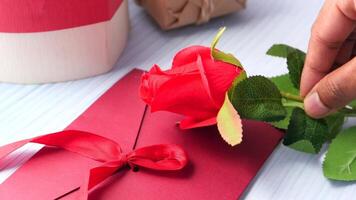 A person is placing a red rose on a red envelope video
