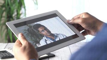 A man is holding a tablet with a of a doctor on it video