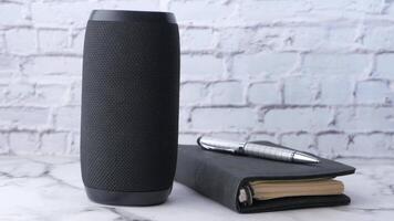 A black speaker and a notebook on a marble counter video
