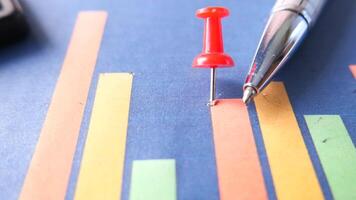 A red pin is placed on a graph chart video