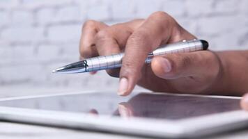 A person holding a pen on a tablet computer video