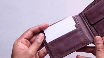 A person holding an empty wallet with a business card video