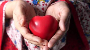 A woman holding a red heart in her hands video