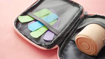 A pink case with a roll of bandages and a pair of scissors video
