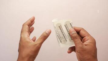 A person holding a piece of paper with a bandage on it video