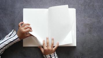 A person holding an open notebook with blank pages video