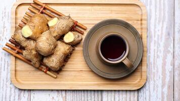 Ginger root on a wooden tray with a cup of tea video