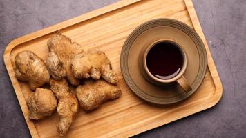 Ginger root on a wooden cutting board with a cup of tea video