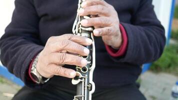 An intimate closeup view of hands skillfully playing a clarinet in a beautiful natural setting video