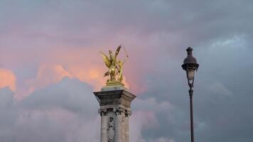 France, Paris - July 24, 2022. Golden statue on tower on background of clouds. Action. Beautiful landscape with golden sculpture on background of colorful evening clouds. Golden Statue of Alexander video