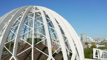 Top view of white domed structure. Stock footage. Beautiful modern building in city center in summer. Architecture of modern circus dome made of white metal arches video