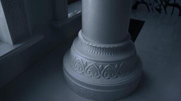 A light white building with dim lighting. Scene. Huge white decorated columns with soft orange illumination. video