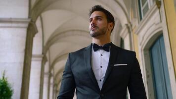 Attractive man with beard in suit. Action. Young elegant man in suit at old building. Gorgeous man with beard and suit video