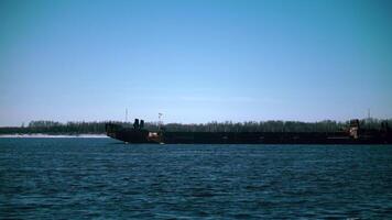 Ferry crossing on river in winter. Clip. Beautiful view of ferry sailing along river on sunny winter day. Ferry sails on blue river in winter video