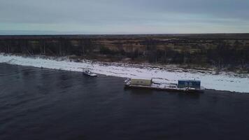 aéreo Visão do uma barcaça em uma inverno rio com gelo. grampo. conceito do água transporte do bens. video