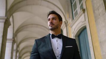Attractive man with beard in suit. Action. Young elegant man in suit at old building. Gorgeous man with beard and suit video