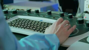 The working process. Stock footage. A woman in a special uniform in a dressing gown and a mask works at a special complex production at a keyboard with additional buttons. video