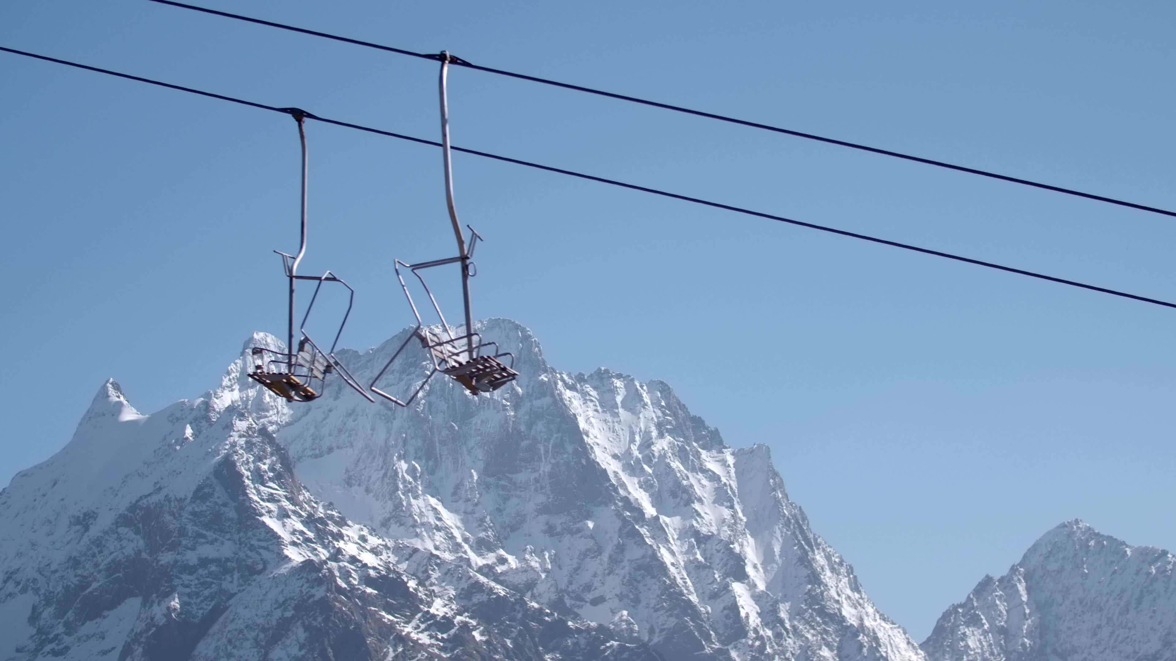 Cable car on background of mountain peaks and blue sky. Creative