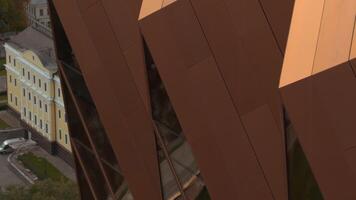 Top view of modern architecture of building with reflection of city. Stock footage. Modern building with gold or metal details and windows. Reflection in modern office building on city tower in summer video