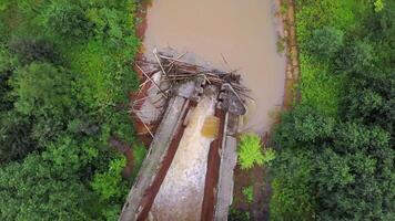 Aerial top view of a river and a dam of tree trunks. Clip. Dirty river and green trees. video