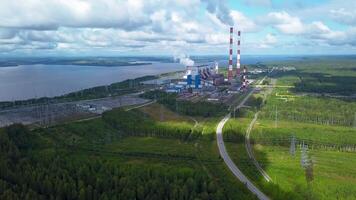 Haut vue de Puissance plante sur Lac rive. agrafe. usine tuyaux sur Contexte de Lac et vert forêt. paysage avec Puissance station et tuyaux par Lac dans été video