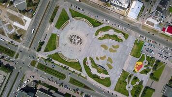 Top view of city square with fountain in summer. Clip. Modern design of fountain in center of square in busy city. Modern square with people and fountain on summer day video