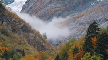 Montagne paysage avec faible des nuages en mouvement dans vallée. créatif. l'automne vallée avec rocheux Montagne pistes et en mouvement des nuages. brumeux faible des nuages mystérieusement bouge toi dans Montagne l'automne vallée video