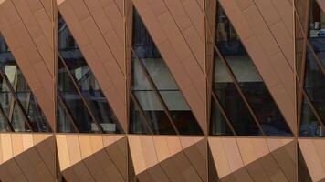 Top view of modern architecture of building with reflection of city. Stock footage. Modern building with gold or metal details and windows. Reflection in modern office building on city tower in summer video