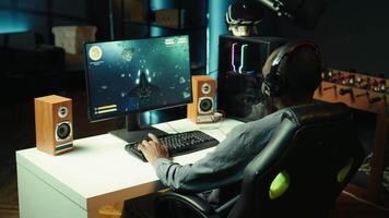 Gamer using headphones to discuss with mates while playing online SF videogame, close up. Close up enjoying futuristic coop spaceship flying arcade game with friends, chatting on internet, camera B video