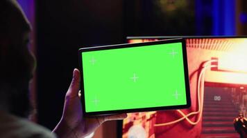 Player watching tutorial guide videos on isolated screen tablet to learn how to win computer videogame. Close up of player looking at mockup device display while enjoying internet multiplayer PC game