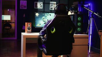 Player at home shooting asteroids in spaceship flying singleplayer game with overlay HUD showing health levels on monitor. Close up of person navigating universe in simulation game on PC video