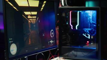 Computer screen showing first person shooter game left open at night in empty apartment with neon lights. Close up of PC on desk in living room with no people in and display left open video