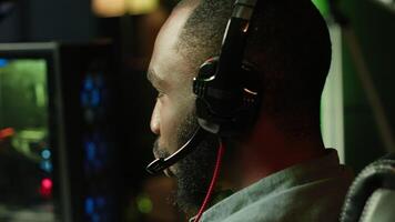 Close up of pro streamer streaming videogame on powerful computer during online gaming championship, talking into headset. Gamer taking part in Esport team of gamers, competing in game, camera A video