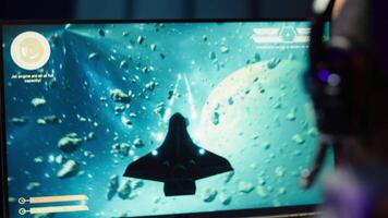 Man at home shooting asteroids in spaceship flying singleplayer game with overlay HUD showing health, fuel, ammo bars and minimap. Gamer navigating universe in simulation game, close up, camera A video