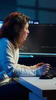Vertical IT expert working from home developing software in JavaScript programming language using desktop PC. System engineer in living room writing lines of code on computer using keyboard, camera A video