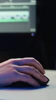 Vertical Extreme close up shot of editor selecting key frames to use while doing montage, working from home on computer. Woman using mouse to edit movie project footage in studio, camera B video