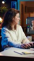 Vertical editor selecting key frames to use while doing montage, working from home on computer. Cheerful woman using mouse to edit movie project footage in office, camera B video